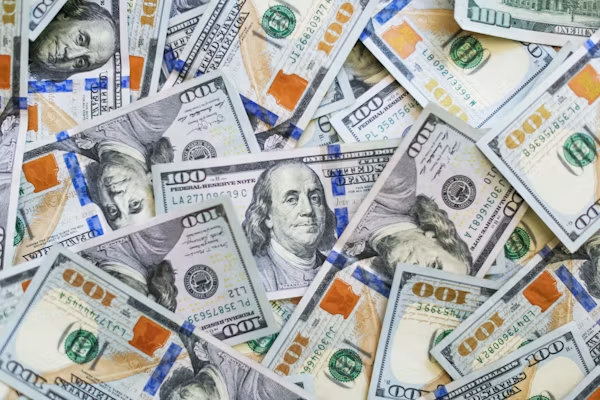 Scattered hundred dollar bills symbolizing massive trillion-dollar sovereign debt obligations